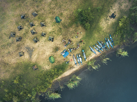 drone view on little camp on island in the lower zambezi river with canoes resting at the shore