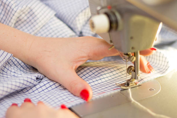 istock Woman taylor is working on the sewing machine closeup a chekered clothes 1316258103