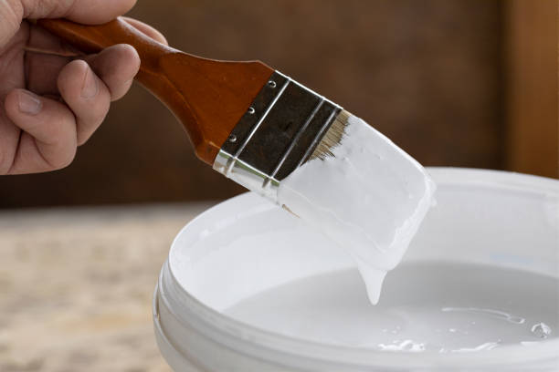 istock man holds brush in his hand ready to paint with white paint 1316259428