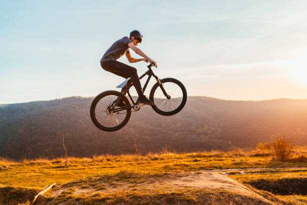 giovane che vola in aria su una mountain bike - dirt jumping foto e immagini stock