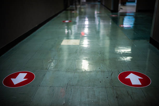 Arrow signs on the floor advising customers regarding social distancing guidelines.