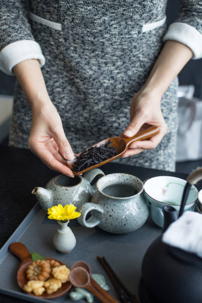istock A woman showing a spoon with dry tea leaves. 1316260582