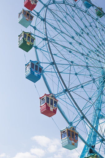 Classic Ferris wheel on blue sky background.