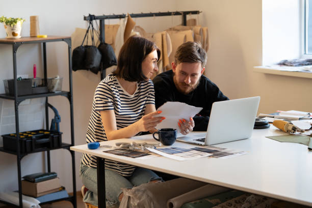 istock Tailors team work in atelier. Designers tailoring business owners choose material for sewing clothes 1316261048