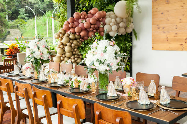 decorazione della festa; un lungo tavolo decorato con fiori per l'accoglienza di un evento sociale. - communion table foto e immagini stock