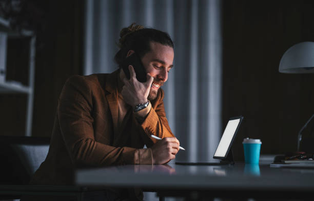 istock Businessman using tablet with stylus pen during phone conversati 1316264176