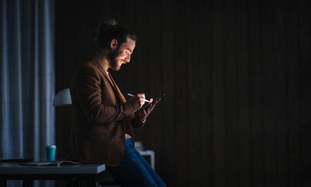 istock Male designer leaning on table and sketching at night 1316264230