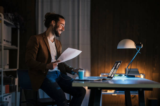 Happy man having video call from dark home office