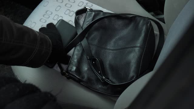 High Angle Shot of Handbag and Cell Phone Being Stolen from Car Seat