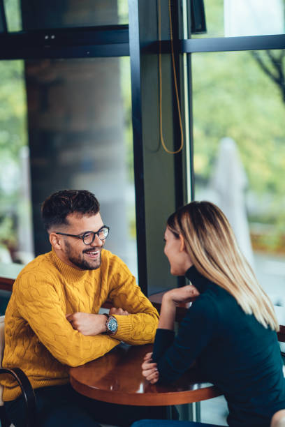 beautiful young couple sitting in a cafe and enjoying time together stock photo