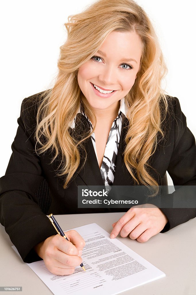 Young Businesswoman Signing a Document A beautiful young  businesswoman woman is signing a document. Adult Stock Photo