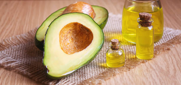 istock Avocado and avocado oil on wooden background. Selective focus 1316267533