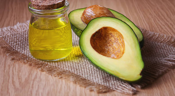 istock Avocado and avocado oil on wooden background. Selective focus 1316267537