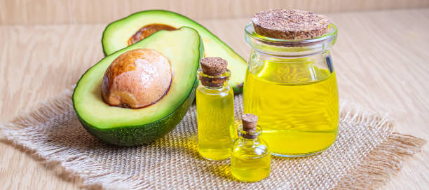 istock Avocado and avocado oil on wooden background. Selective focus 1316267569