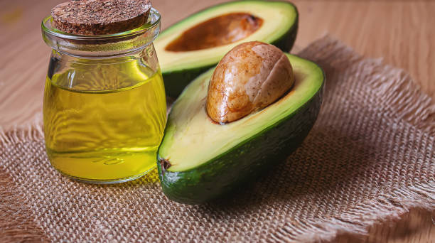 istock Avocado and avocado oil on wooden background. Selective focus 1316267581