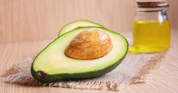 istock Avocado and avocado oil on wooden background. Selective focus 1316267595