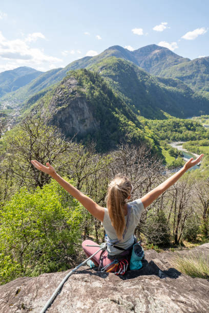 istock Female mountain climber arms outstretched on mountain top 1316268636