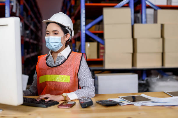 istock Engineer woman wearing a hardhat standing cargo at goods or merchandise warehouse and check control loading from Cargo freight ship for import and export. Teamwork successful concept. 1316269116