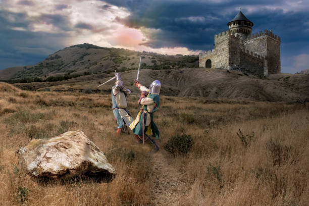 Jousting duel of honor fight between two knights near the castle against the background of the sunset sky. middle ages chivalry stock pictures, royalty-free photos & images