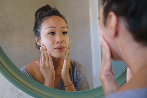 Mujer indonesia lavándose la cara usando jabón limpiador de belleza photo