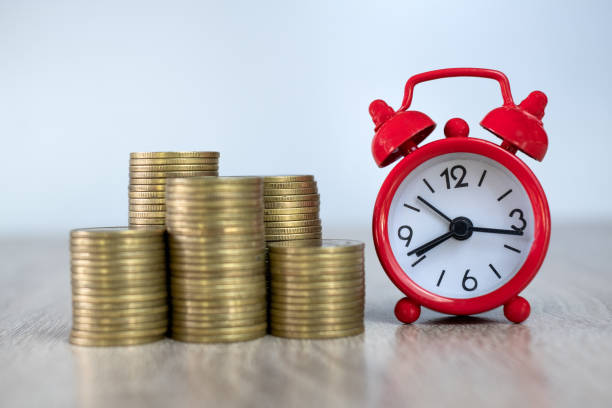 ein roter wecker und ein haufen münzen konzept von zeit und finanziellen risiken geschäftsinvestitionen sollten rechtzeitig sein. buchhaltung und marketing. - number alarm clock clock hand old fashioned stock-fotos und bilder