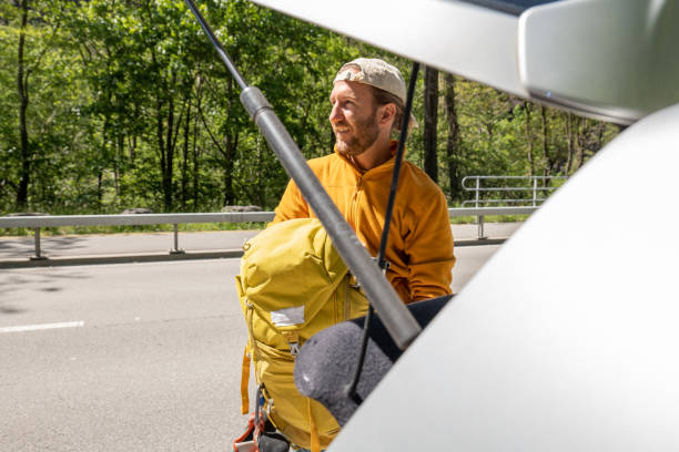 istock Man unloading climbing equipment from hatchback of a car 1316271439