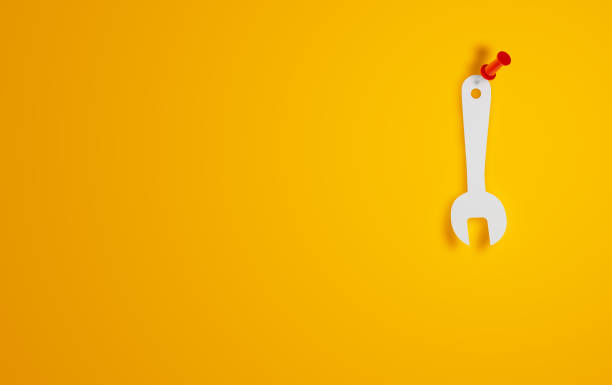 символ гаечного ключа на желтом фоне - screwdriver screw tighten fastener стоковые фото и изображения