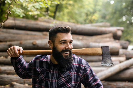Mid adult man working as a lumberjack in a forest. About 35 years old, Caucasian male.