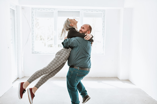 Happy Couple Dancing Together Out Of Happiness For Buying New Apartment