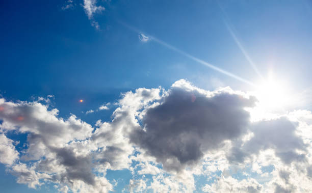 istock Clouds and sun shining on blue sky background 1316274195