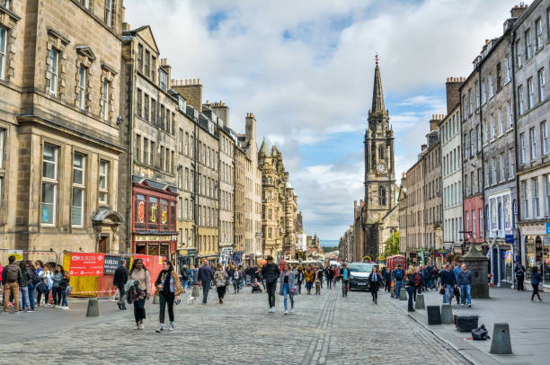 View looking east down the High Street section of Royal Mile past the old Tron Kirk in Edinburgh, Scotland. Edinburgh, United Kingdom - September 8, 2017. View looking east down the High Street section of Royal Mile past the old Tron Kirk in Edinburgh. View with people and commercial properties. midlothian scotland stock pictures, royalty-free photos & images