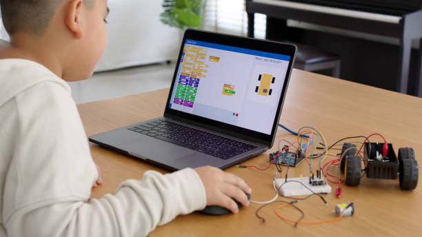 istock Young asia student remotely learn online at home in coding robot car and electronic board cable in STEM, STEAM, mathematics engineering science technology computer code in robotics for kids concept. 1316278363