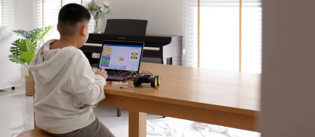 istock Young asia student remotely learn online at home in coding robot car and electronic board cable in STEM, STEAM, mathematics engineering science technology computer code in robotics for kids concept. 1316278587