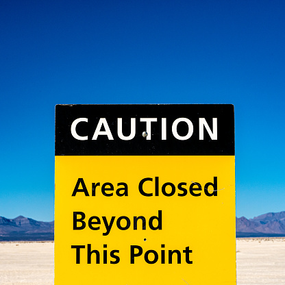Caution Area Closed Sign on Blue Sky in White Sands National Park