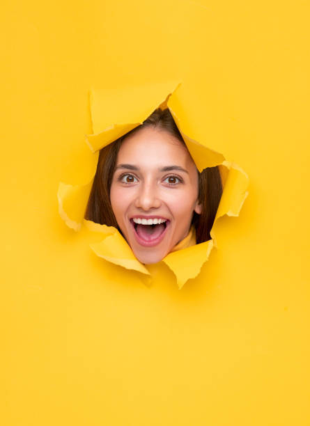 istock Excited woman in torn paper hole 1316282229