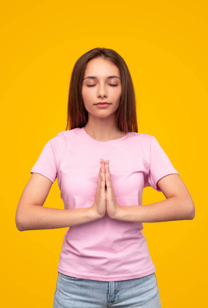 istock Young woman meditating with closed eyes and clasped hands 1316282265