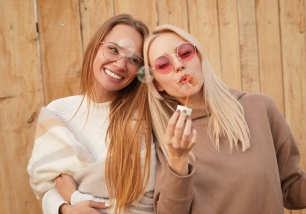 istock Cheerful women blowing bubbles together 1316282350