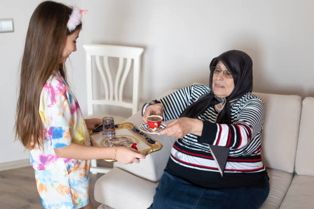 Granddaughter offering coffee to grandmother