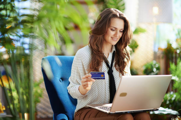 smiling elegant woman in sunny day using laptop