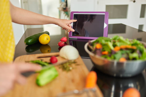 istock A woman checks a recipe on her digital tablet while cooking 1316285835