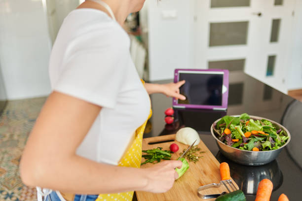 istock A woman checks a recipe on her digital tablet while cooking 1316285971