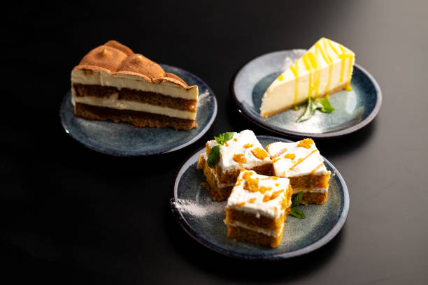 istock A few different desserts, assorted sweets on plates on a black background. Vanilla classic and chocolate cake, carrot cake. 1316286350