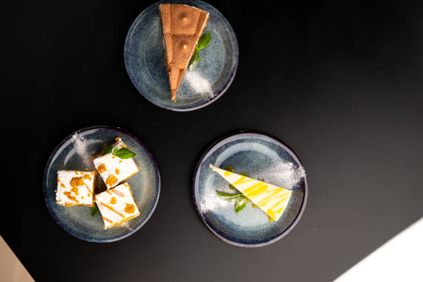 istock A few different desserts, assorted sweets on plates on a black background. Vanilla classic and chocolate cake, carrot cake. 1316286490