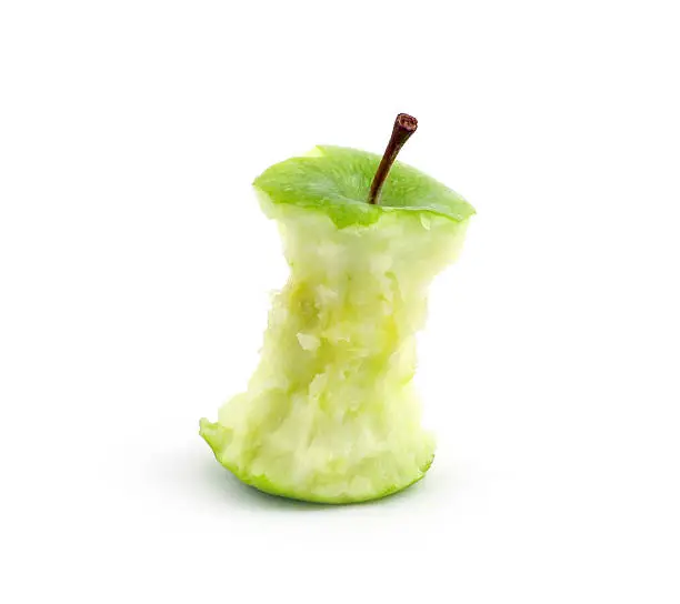 Green apple core against a white background