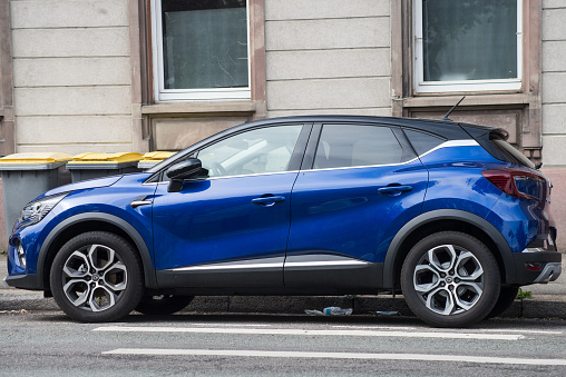 Mulhouse - France - 4 May 2021 - Profile view of blue Renault Captur SUV car parked in the street