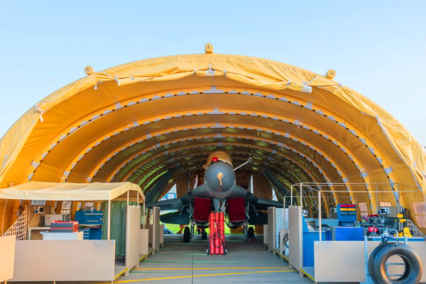 air force fighter jet in the parking lot in the mobile hangar tactical base, rapidly deployable complex. - fuel and power generation air vehicle repairing airplane imagens e fotografias de stock