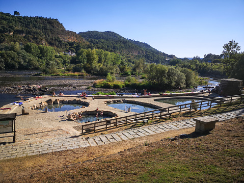 August 5, 2020 - Ourense, Spain: People taking a thermal bath in the open to pubilc Termas do Muíño da Veiga near Miño river
