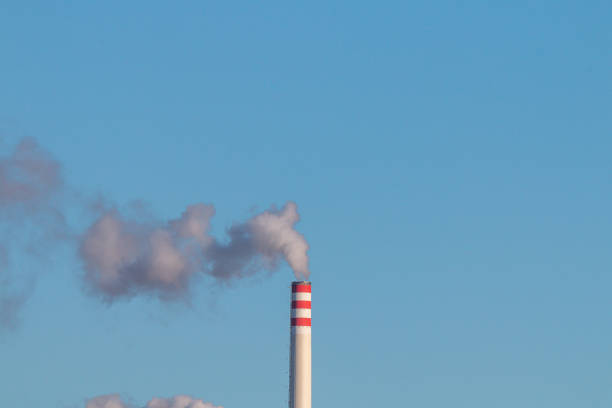 Smoking chimney in front of a blue sky