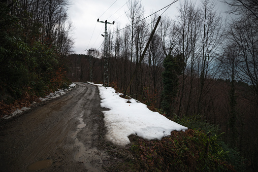 snowy and muddy mountain road.\nLamppost and street lighting in winter and at sunset.