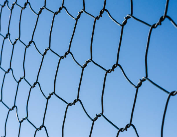 istock Metal mesh chain link close-up against the blue sky. 1316295238
